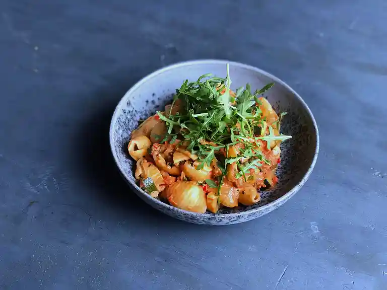 Pasta i cremet tomatsauce med chili, squash og rucola