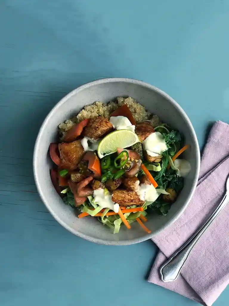 Quinoa bowl med krydret svinekam, tomat, kål og creme fraiche