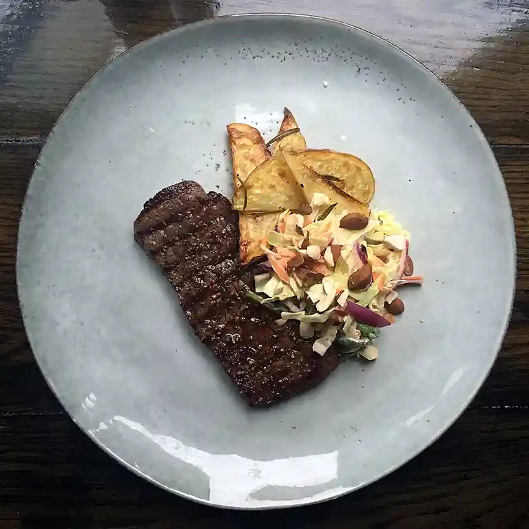 Steak af inderlår med ovnfritter, coleslaw med ristede mandler og snack-grønt